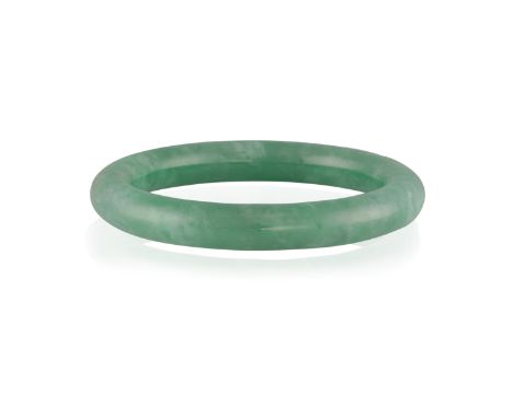A JADEITE JADE BANGLE, the translucent jadeite bangle of green hue, suffused with white patches, inner diameter approximately