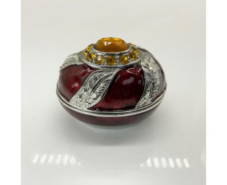 This small, elegant jewelry box features a stunning large crystal centerpiece atop a lid adorned with intricate silver spiral