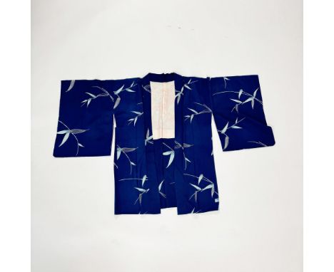 A navy breathable silk robe with a printed bamboo leaf pattern. Known as a yukata, this summer kimono is designed for casual 