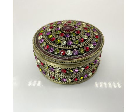 This stunning round ring box is adorned with sparkling red, purple, green, and light-yellow crystals and features an enameled