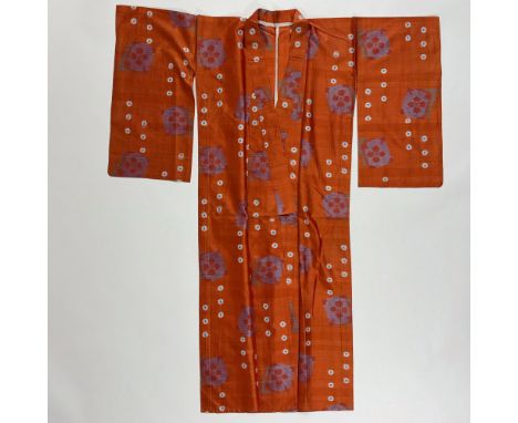 A beautiful orange Japanese kimono with circular patterns woven from threads of different colors on traditional silk known as
