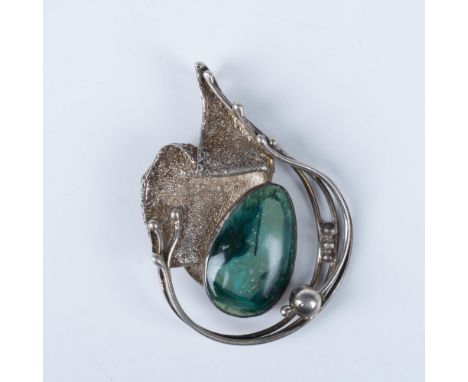 This silver brooch features a green stone and an avantgarde design. Marked 925. Weighs 26g. Issued: 20th centuryDimensions: 3