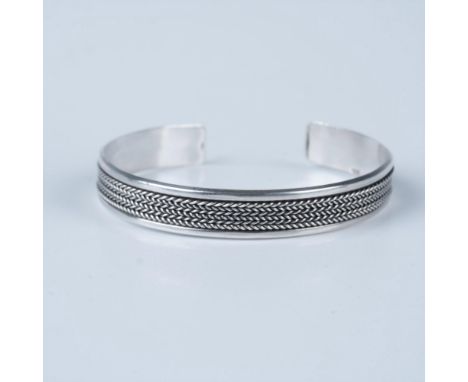 This stylish silver bracelet features a stunning braided detail. Easily adjustable with a gentle squeeze. Measures 2.5" dia. 