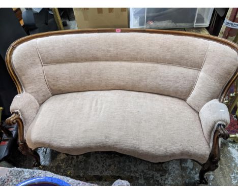 A late Victorian carved mahogany sofa, scrolled end arms, knee carved French cabriole legs with scrolled end front feet, on c