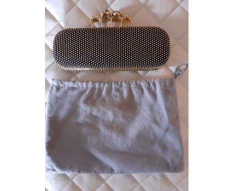 Alexander McQueen-A fabric clutch bag with gold tone four ring knuckle duster clasp with skull and jewel detail, the fabric d