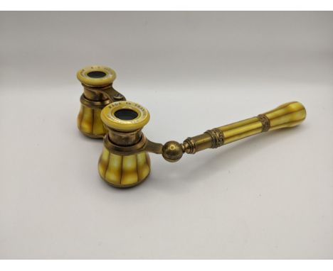 An early 20th century French yellow mother of pearl opera glasses, retailed by H C Abbott & Bro, Birmingham, with engraved or