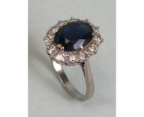 18ct white gold cluster ring of an oval cut sapphire surrounded with 12 diamonds, approximately 3.6g size R