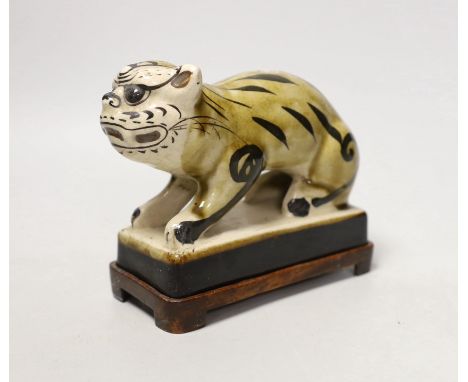 A Chinese Cizhou style pottery ‘tiger’ incense stick holder on wood stand, 13cm tall