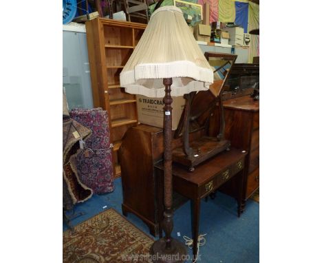 A finely carved hardwood standard lamp with profuse floral/leaf decoration, with cream pleated shade, 54" tall overall.
