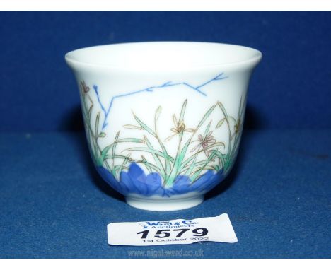 A reproduction Chinese porcelain 'Month' cup decorated with orchids, underglaze blue Chinese calligraphy and a six character 