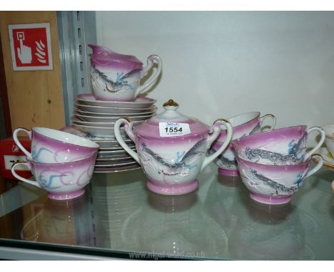 An oriental part teaset in pink and white having gilt rims and handles and hand-painted dragon detail including six cups, sau