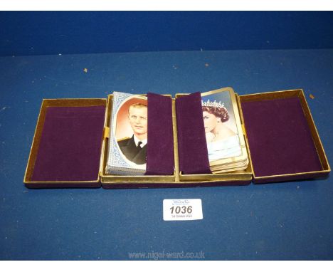 A collectable felt and gilt box stamped E.R. and crown containing gilt edged packs of playing cards with images of Queen Eliz