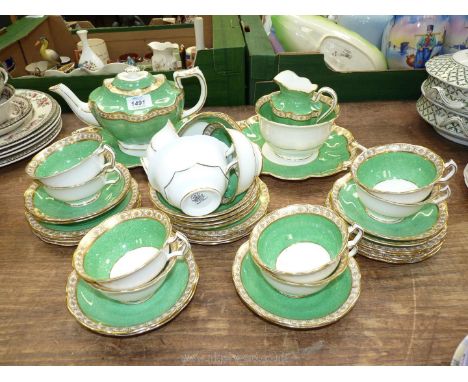 A tea set in green with gilt coloured edges by George Jones &amp; Sons to include; teapot, sugar bowl, milk jug, 12 cups &amp