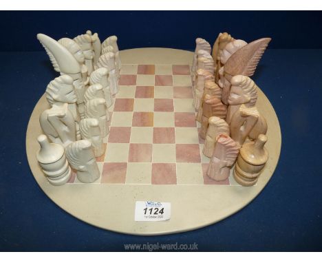 A complete stone Chess set in pink and cream depicting figures (chip to one pink pawn).