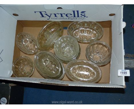 A quantity of glass jelly moulds and a lemon squeezer.
