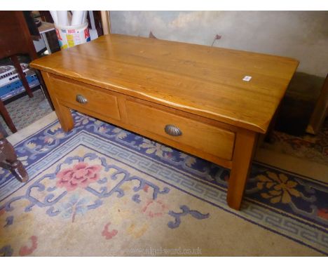 A French light Oak Coffee Table having a pair of short drawers to one side and standing on substantial square legs, 1.10 m. l