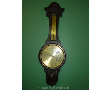 A barometer in dark wood with brass face.