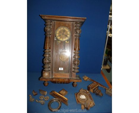 A wall clock with enamel and brass face having Roman numerals, with key and pendulum, in need of repair.