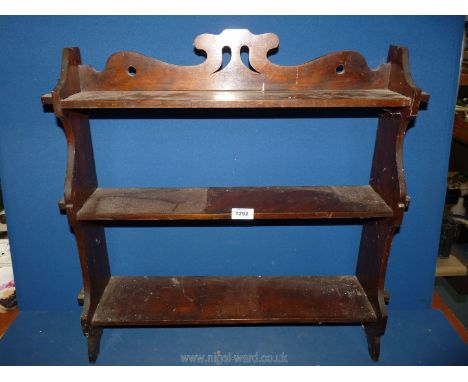 A dark Mahogany table top or wall hanging Shelf unit with fretworked detail, the three shelves retained by pegs, 25 3/4'' x 2