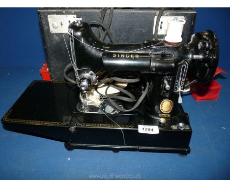 A cased Singer Featherweight 222K compact electric Sewing Machine, complete with machine feet and pedal.