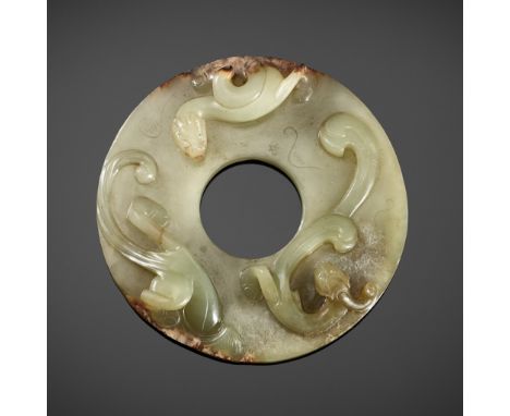 A CELADON JADE DISC WITH COILED DRAGONS, WESTERN HAN DYNASTYChina, Western Han dynasty, c. 2nd -1 st century BCA very fine ce