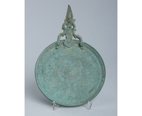 AN INDONESIAN BRONZE MIRROR, 19TH CENTURYJava, 19th century or earlier. The back of the circular dish with concentric rings e