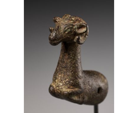 A LURISTAN BRONZE 'RAM' WHETSTONE FINIAL, CIRCA 1000-650 BCFinely cast in the form of a recumbent ram, the tubular base is ho