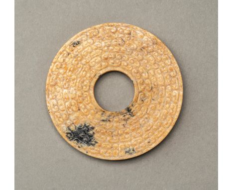 A SMALL JADE BI DISC, QINGChina, Qing Dynasty (1644-1912) or earlier. The disc is neatly decorated with archaic motifs of s-s