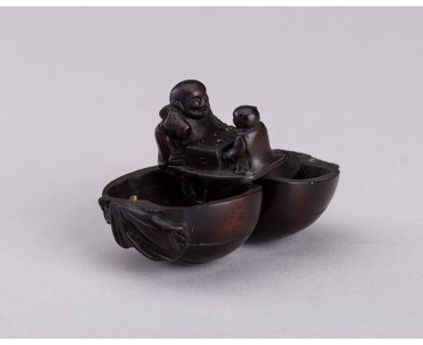 A WOOD KARAKURI NETSUKE WITH HOTEI AND KARAKO PLAYING SUGOROKU, MEIJIJapan, Meiji period (1868-1912)The exterior well carved,