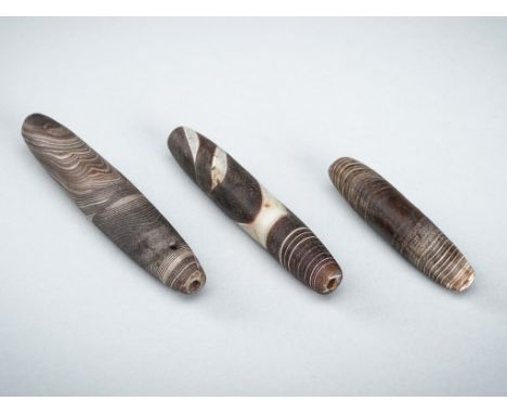 A GROUP OF THREE WESTERN ASIATIC BANDED AGATE BEADS, 1ST MILLENNIUM BC OR EARLIERThe semitranslucent beads of tubular form, t