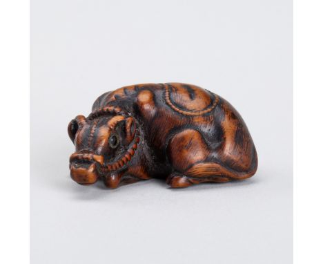 A WOOD NETSUKE OF A RECUMBENT OXInscribed Tomotada 友忠Japan, 19th centuryBoldly carved, the ox seated on its legs craning its 