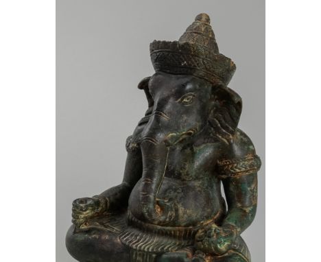 A KHMER-STYLE BRONZE FIGURE OF GANESHAThailand or Cambodia, c. 17th century or later. Cast as Ganesha seated in dhyanasana, h