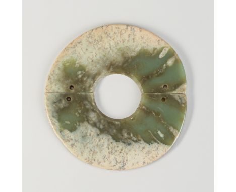 A JADE TWO SECTION DISC, QIJIA CULTUREChina, Qijia culture, c. 2200-1600 BC. The mottled celadon jade disc showing numerous s