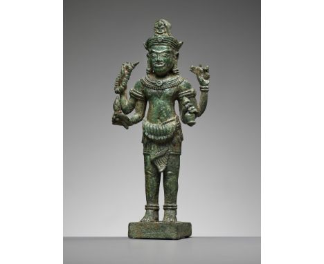 A KHMER BRONZE FIGURE OF AVALOKITESHVARA, ANGKOR PERIODKhmer Empire, 12th century. The bodhisattva standing in samapada on a 