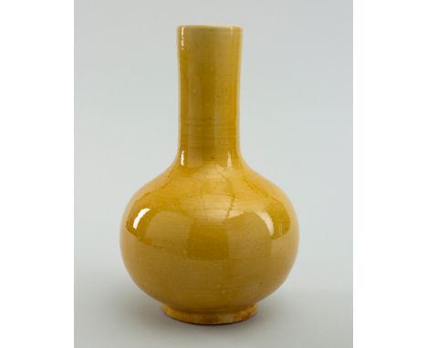 A YELLOW-GLAZED PORCELAIN BOTTLE VASE, TIANQIUPING, QING DYNASTYChina, Qing Dynasty (1644-1912). Of globular form, rising fro