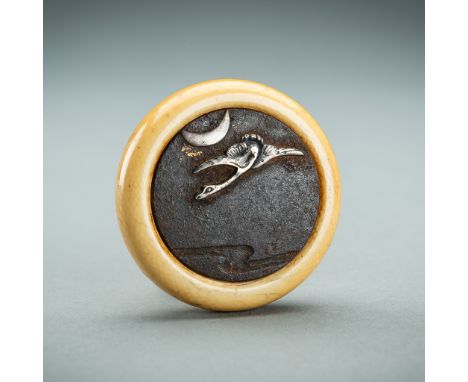 AN IVORY AND IRON KAGAMIBUTA NETSUKE DEPICTING A CRANE AND THE MOON, EDOJapan, 19th century, Edo period (1615-1868)Of circula