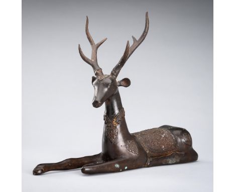 A LARGE BRONZE FIGURE OF A CAPARISONED DEER, 19TH CENTURYBurma, 19th century. Finely cast, the recumbent six-point stag exten