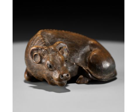 HIDARI ISSAN: A SUPERB WOOD NETSUKE OF A RECUMBENT OXBy Hidari Issan, signed Hidari Issan 左一山Japan, Iwashiro Province, c. 184