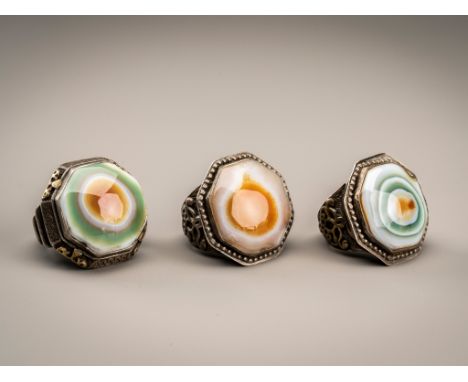 A GROUP OF THREE HIMALAYAN BUDDHA EYE AGATE INSET SILVER RINGSHimalayan region, late 19th century. Each ring inset with a dom