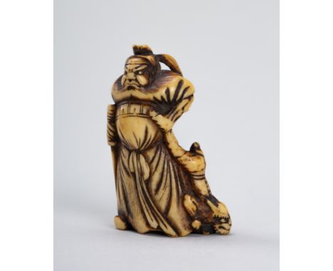 A FINE ANTLER NETSUKE OF SHOKI AND ONIJapan, Edo period (1615-1868)Finely carved, the fierce Shoki standing dragging a resist