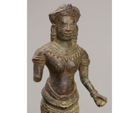 A BRONZE FIGURE OF UMA, ANGKOR PERIOD, 12TH-13TH CENTURYKhmer Empire. Standing in samabhanga, dressed in a pleated sampot sus