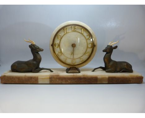 Art Deco mantle clock with circular face flanked by two recumbent bronzed deer. 