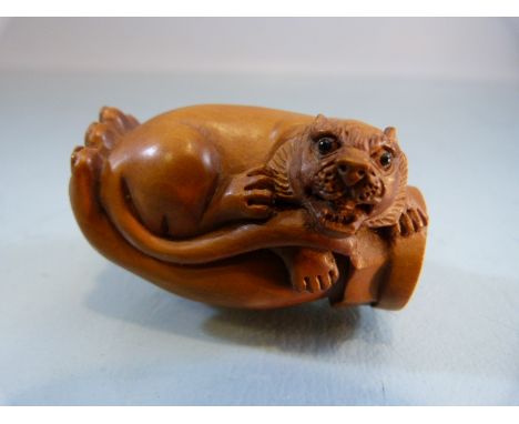 Carved wooden Netsuke of a hand holding a 'lion'