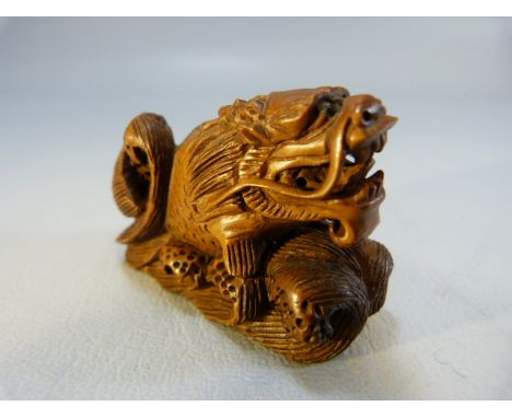 Carved wooden Netsuke of a dragon among water