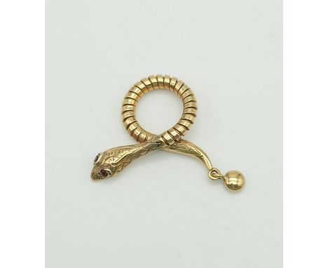 9k yellow gold snake pendant with ruby eyes, 35mm in length, weighs 4.3 grams 