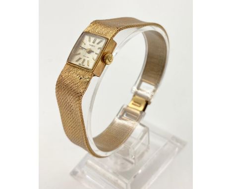 A 9K Yellow Gold Tissot Ladies Watch. Gold strap and case. Mother of Pearl tone dial. Quartz Movement.Case 14 x 14mm. In work