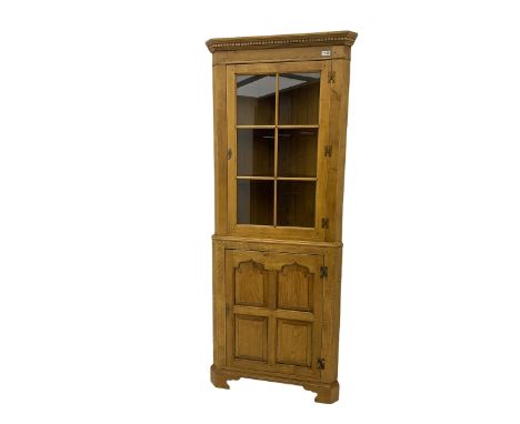 Traditional light oak corner cabinet, projecting cornice, dentil frieze, single glazed door above single fielded doorDimensio