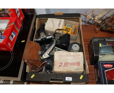 A box containing Nikon camera, Polaroid camera, various accessories