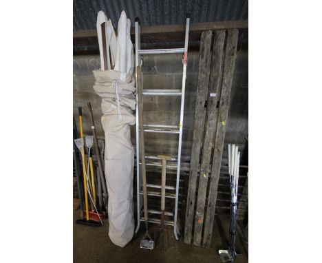 A set of metal steps together with a long handled garden hoe and a garden fork