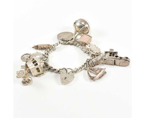 A silver charm bracelet with intaglio seal fob charm. The silver charm bracelet having eleven large silver charms strung on a